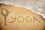 le mot yoga dans du sable